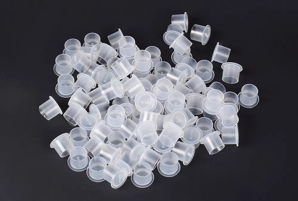 Hard plastic tattoo cups for tattoo inks and diferent pigments, conected to the skin art.
