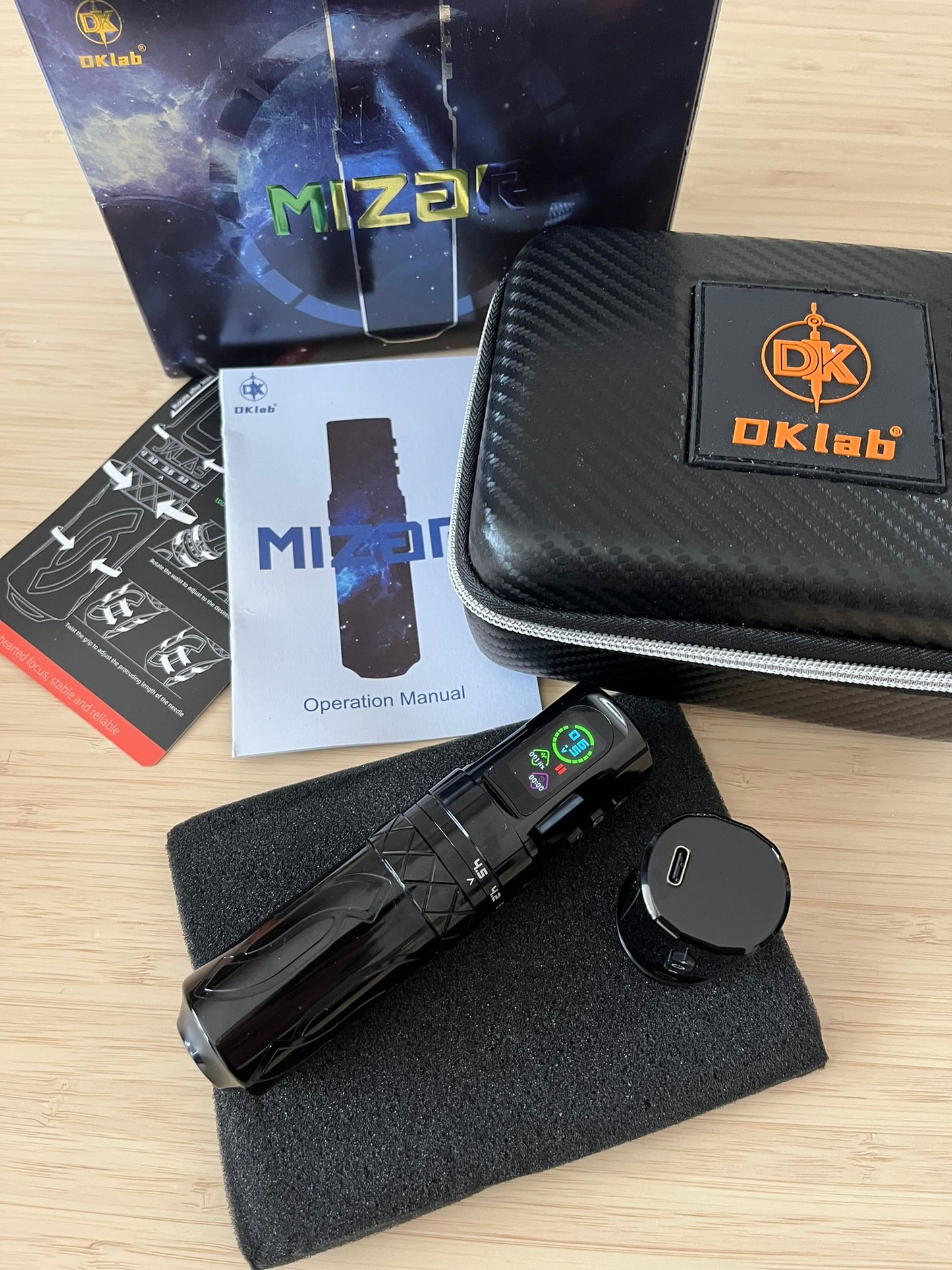 Complete DKlab tattoo kit including the black machine, accessories, operation manual, and branded packaging.