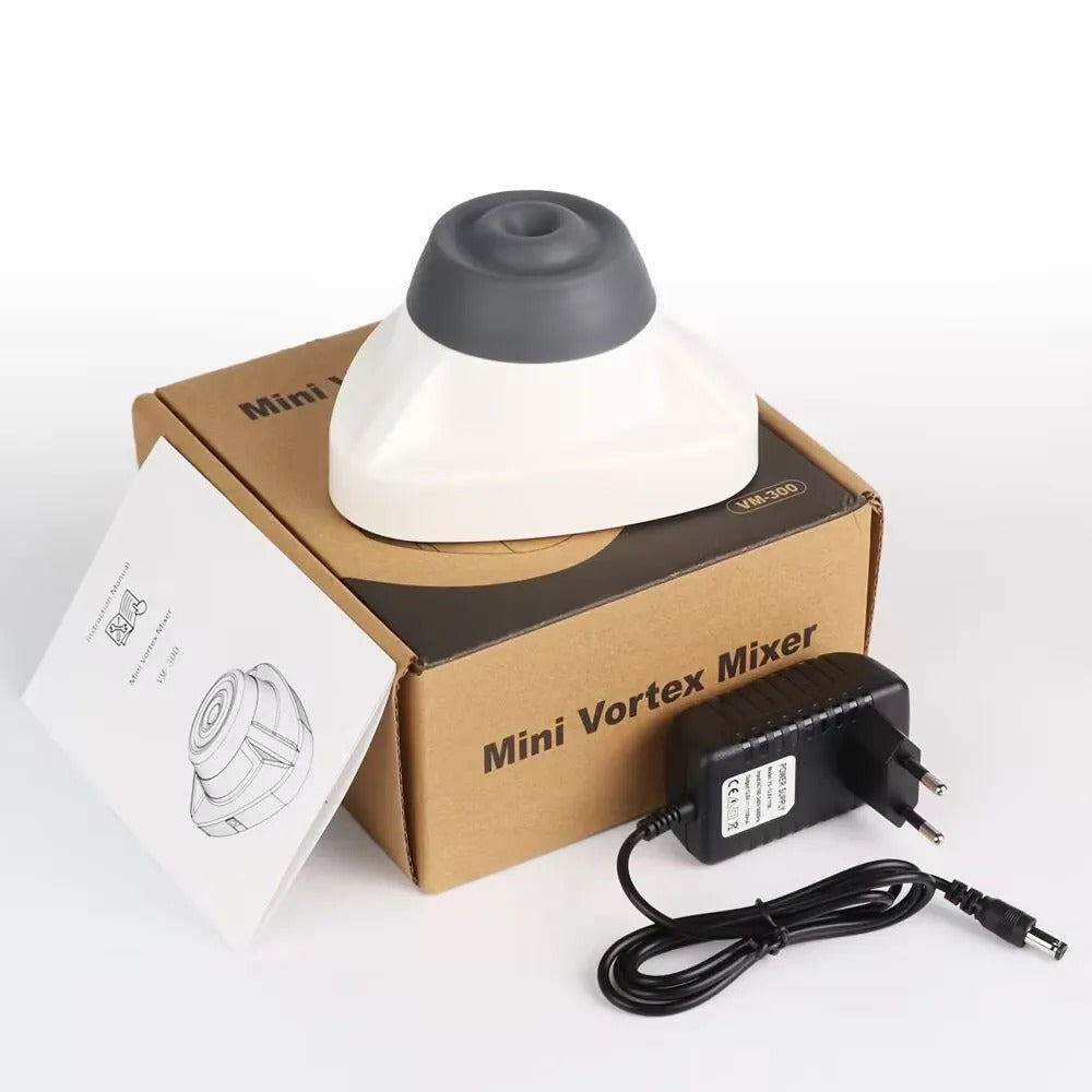 Image of a white Mini Vortex Mixer kit featuring the mixer placed on its packaging box. The kit includes an instruction manual and a power adapter, showcasing a compact design suitable for laboratory or small-scale mixing applications.
