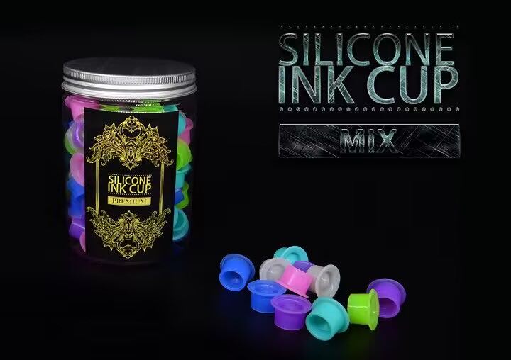 Jar of silicone ink cups with premium design displayed alongside individual cups, ideal for professional tattooing setups.