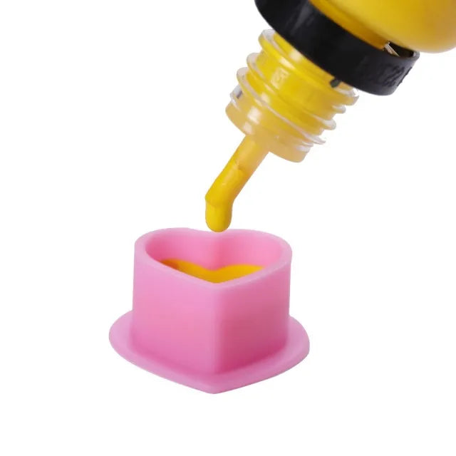 Close-up view of silicone ink cups being filled with tattoo ink.
