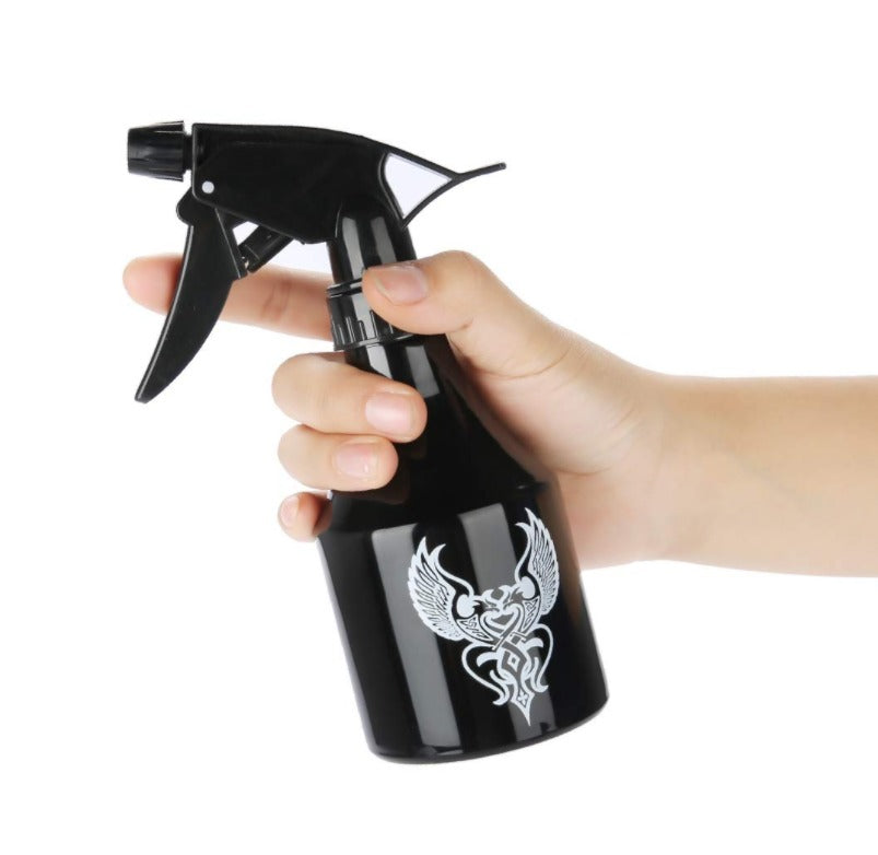 Sleek black spray bottle with ergonomic design and tribal tattoo print, ideal for cleaning tattoo studios.