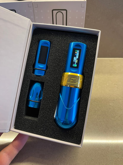 A real photo of a blue and gold Vex tattoo machine in its box.