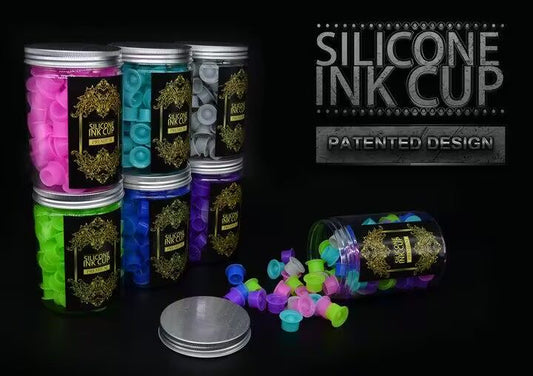 Colorful silicone ink cups in jars with a patented design, displayed in vibrant pink, green, blue, purple, and gray options. Perfect for professional tattoo use.