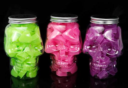 SKULLDNA silicone ink cups in vibrant colors, presented in skull-shaped jars, ideal for professional tattoo use.