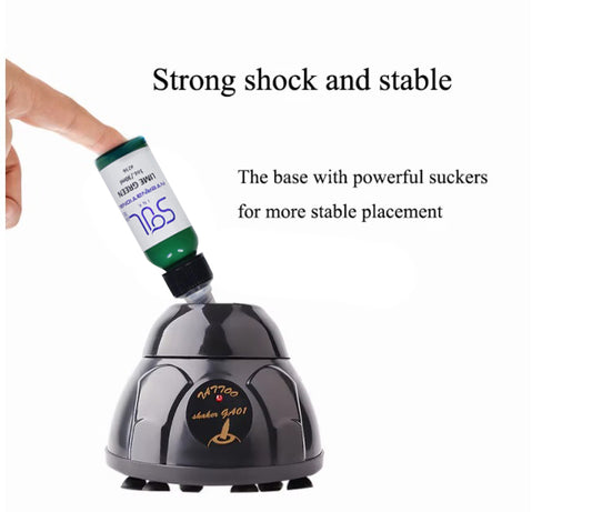 Tattoo ink mixer with suction base for stable placement, showing a green ink bottle being mixed.